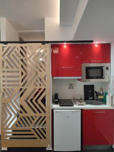 a kitchen with red cabinets and a white counter top at THEASIS 4 luxury studio with sea view in Neos Marmaras