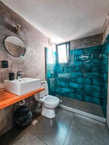 a bathroom with a sink and a toilet and a shower at MedioMundo Hostel in Montevideo
