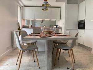 une cuisine avec une table et des chaises ainsi qu'une salle à manger dans l'établissement Superbe appartement avec jardin Saint Charles, à Biarritz