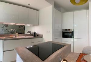 une cuisine avec des placards blancs et un comptoir dans l'établissement Superbe appartement avec jardin Saint Charles, à Biarritz