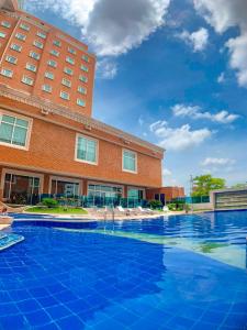 a hotel swimming pool in front of a building at Hotel Dann Carlton Barranquilla y Centro de Convenciones in Barranquilla