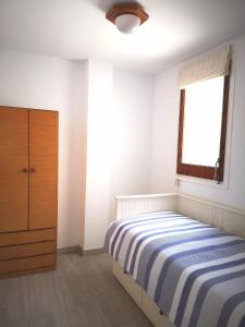 a bedroom with a bed and a window and a dresser at ÁTICO FRENTE AL MAR in Canet de Mar +5 photos