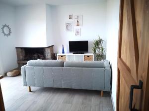 - un salon avec un canapé et une télévision dans l'établissement ÁTICO FRENTE AL MAR, à Canet de Mar