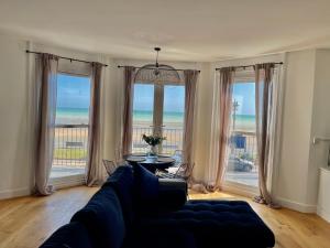 a living room with a couch and views of the ocean at Seaview flat with balcony, spacious 2 bedroom in Worthing
