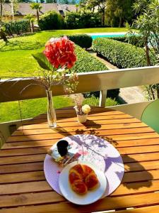 a table with a plate of fruit and a vase with flowers at Garden Pool Apartment in Merano