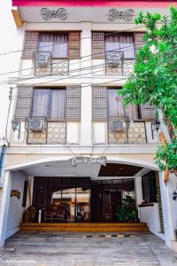 ビガンにあるCasa De Soledad Vigan Cityの白い大きな建物(窓、ポーチ付)