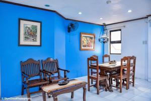a dining room with blue walls and a wooden table and chairs at Casa De Soledad Vigan City in Vigan