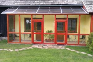 a screened in porch with red doors and chairs at Privat AVE in Liptovský Trnovec