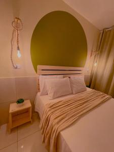 ein Schlafzimmer mit einem großen Bett mit gelber Wand in der Unterkunft Vanilla in Porto De Galinhas