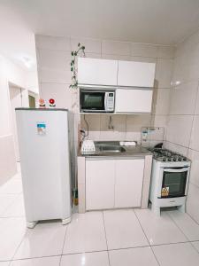 eine kleine Küche mit einem Kühlschrank und einer Mikrowelle in der Unterkunft Vanilla in Porto De Galinhas
