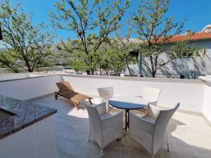 a patio with a table and chairs on a roof at Apartments Buljanovic in Pag