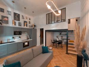Il comprend un salon avec un canapé et une cuisine avec une table. dans l'établissement Le Somptueux - Les Maisons de Madeleine, à Nantes