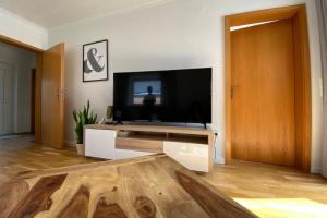 uma sala de estar com uma televisão e uma mesa de madeira em Ferienapartment Weber em Faßberg