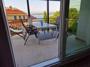 a patio with a table and chairs on a balcony at Anna24 Holidays in Vantačići