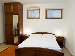1 dormitorio con 1 cama con sábanas blancas y 2 ventanas en Bed&Breakfast Kvarner, en Labin
