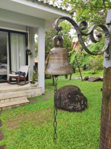 瓜皮米林的住宿－Casa confortavel pra relaxar na serra，挂在院子中一根杆上的钟