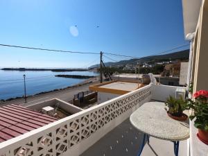 a balcony with a table and a view of the water at AGIAS PELAGIAS LITTLE BEACH HOUSE in Agia Pelagia Kythira