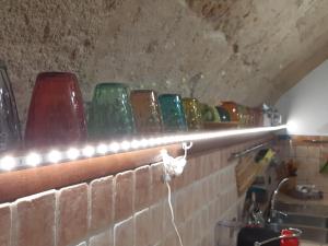 een plank met verschillende gekleurde glazen vazen erop bij Che bella vita! in Monopoli +81 foto's