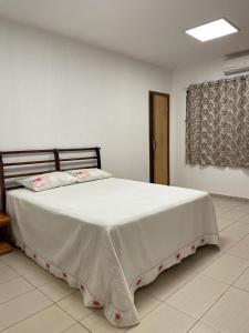1 dormitorio con 1 cama blanca grande en una habitación en Morada da Lua, en Foz do Iguaçu