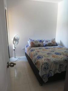 1 dormitorio con 1 cama con lámpara y almohada en ApartaLujo Tu Estancia de Ensueño, en Santa Marta