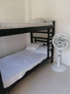 1 dormitorio con litera y ventilador en ApartaLujo Tu Estancia de Ensueño, en Santa Marta