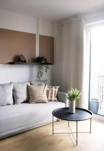 ein Wohnzimmer mit einem Sofa und einem Tisch in der Unterkunft Przestronne apartamenty na Mazurach in Angerburg
