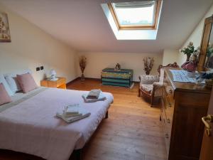 a bedroom with a large bed and a skylight at La casetta sui colli in Perarolo