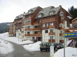 duży budynek apartamentowy przy pokrytej śniegiem ulicy w obiekcie Appartement Le Pleynet, 1 pièce, 3 personnes - FR-1-557A-26 w mieście La Ferrière