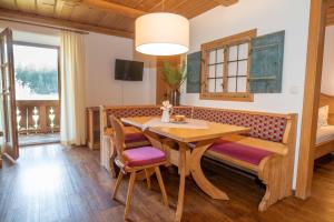 uma sala de jantar com uma mesa e cadeiras e uma cama em Knoglerhof em Ruhpolding
