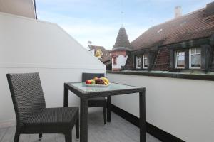 - une table et des chaises sur un balcon avec un bol de fruits dans l'établissement Apartmenthaus zum Trillen Basel City Center, à Bâle