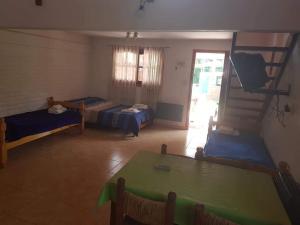 Habitación con 2 camas y mesa. en Cabañas Wayramuyu en Merlo