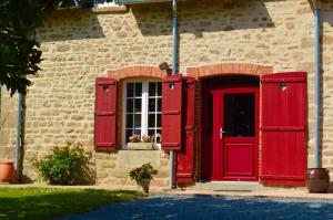 Isigny-le-Buat的住宿－La Pichonnière，砖楼上的红门和窗户