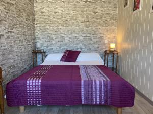 a bedroom with a bed with a purple blanket at Appartement Erdeven, 3 pièces, 4 personnes - FR-1-397-47 in Erdeven