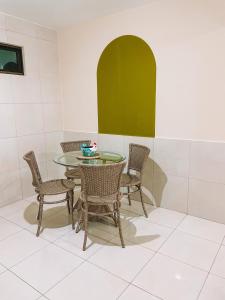 uma sala de jantar com uma mesa de vidro e cadeiras em Vanilla em Porto de Galinhas