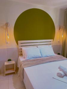 Bett mit grünem Kopfteil in einem Zimmer in der Unterkunft Vanilla in Porto De Galinhas