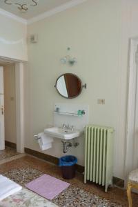 baño con lavabo, espejo y radiador en Pensione Seguso, en Venecia