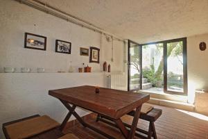 a dining room with a wooden table and a window at Two Olives in Vrbnik