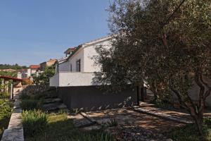 a house with a wall and a tree at Two Olives in Vrbnik