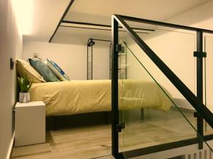 Schlafzimmer mit einem Bett mit Glaswand in der Unterkunft Precioso Loft a 150 metros de la playa in Santa Pola