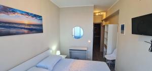 a bedroom with a bed and a flat screen tv at B&B Aria di Mare - Pollina Sicilia in Finale