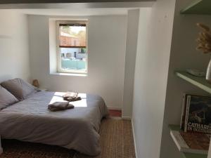 a bedroom with a bed with a window at Appartement climatisé avec terrasse in Carcassonne