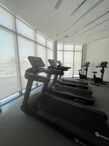 a gym with several treadmills and a laptop on a treadmill at Relaxing villa with access to pool and beach in Ras al Khaimah