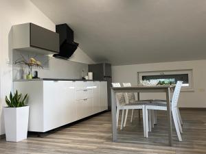 a kitchen and dining room with a table and chairs at Apartma Fojana in Dobrovo
