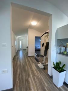 ein leeres Wohnzimmer mit Laufband und Fitnessraum in der Unterkunft Apartma Fojana in Dobrovo