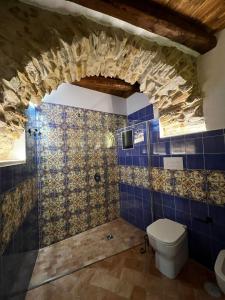 baño con aseo y pared de azulejos azules en Antica Dimora Aragonese, en Agropoli
