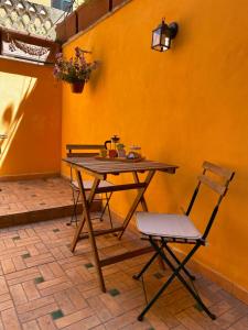 una mesa de madera y sillas frente a una pared amarilla en APT a due passi da San Pietro, en Roma