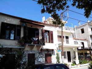 a white house with a car parked in front of it at Paris & Eleni in Afissos
