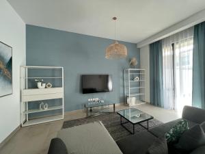 a living room with a couch and a tv at Relaxing villa with access to pool and beach in Ras al Khaimah