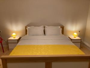 Borjomi Yellow Hotel في بورجومي: غرفة نوم مع سرير مع مصباحين على طاولتين