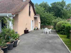 a patio with a table and chairs in front of a house at ELLO HAPPINESS HOME place to be in pau in Pau